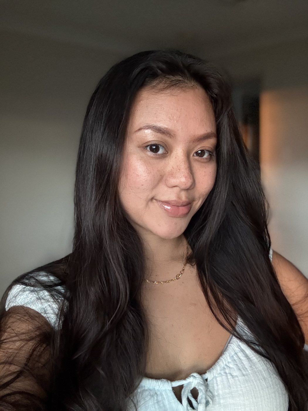 Ismriti smiling at the camera, long dark hair, natural light