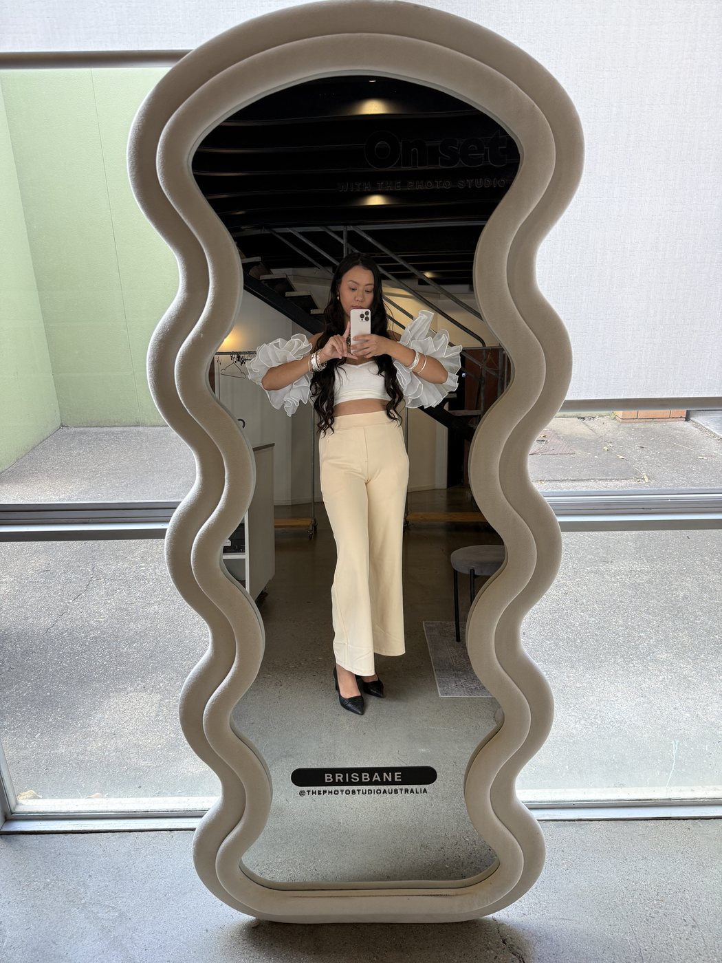 Ismriti taking a mirror selfie in a wavy-edged mirror